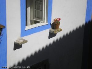 Sul muro di una casa di Obidos (Portogallo), l'ombra del cornicione della casa accanto costituisce un esempio di fregio.